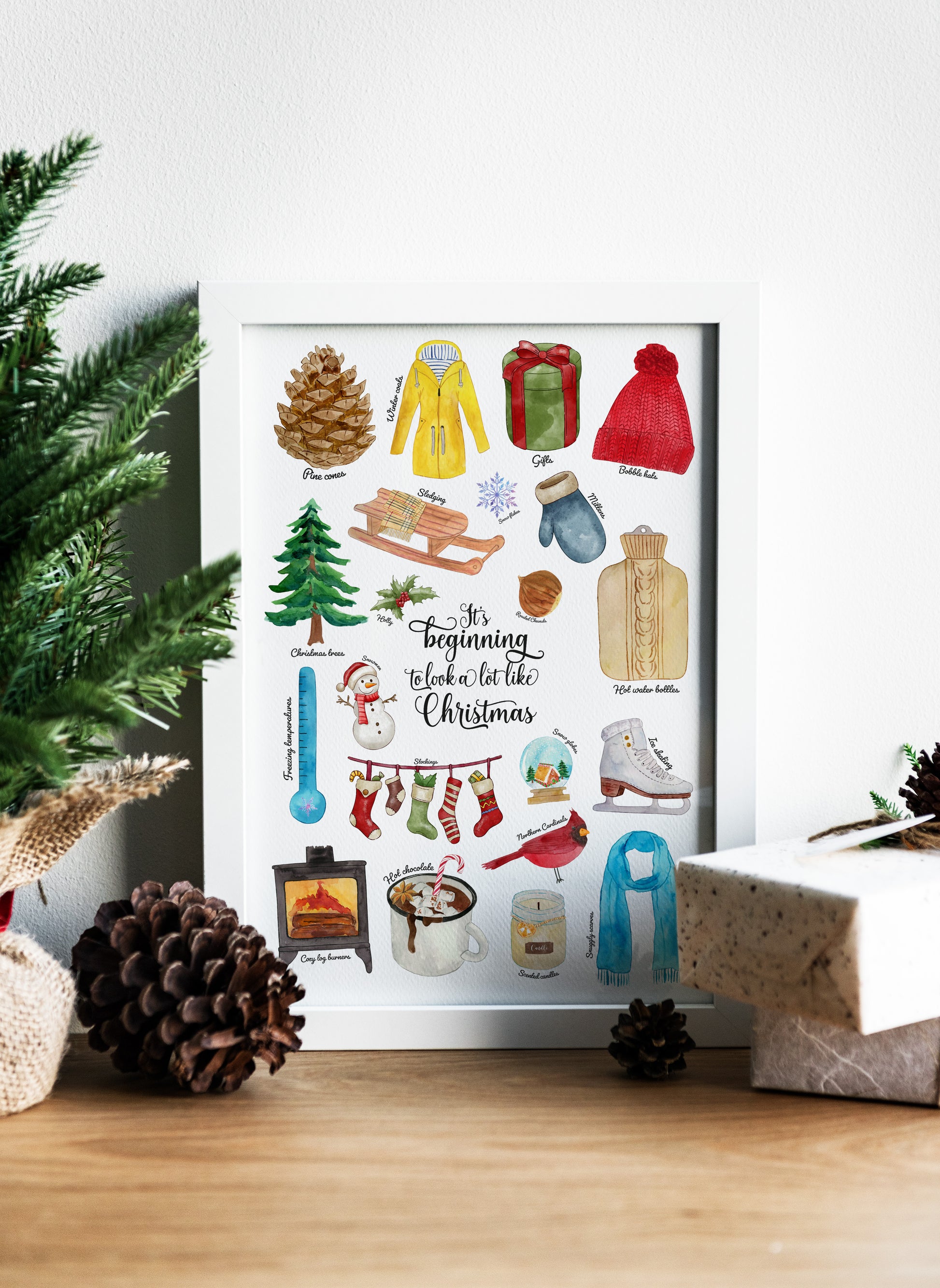 Framed artwork with winter-themed illustrations on a decorative surface with Christmas decor.