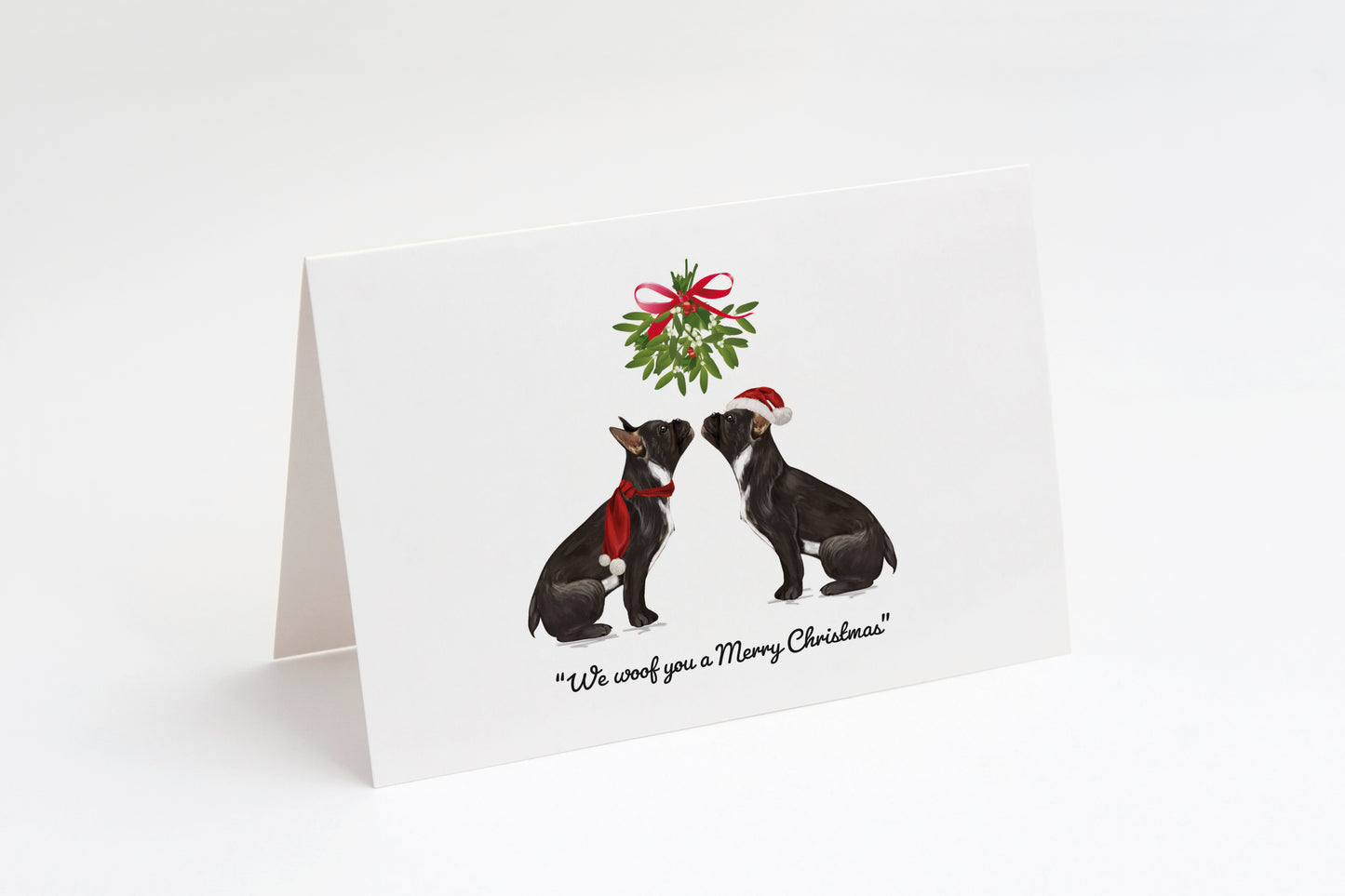 Christmas card with two black French Bulldogs and a wreath on a white background. "We woof you a Merry Christmas!" text underneath.
