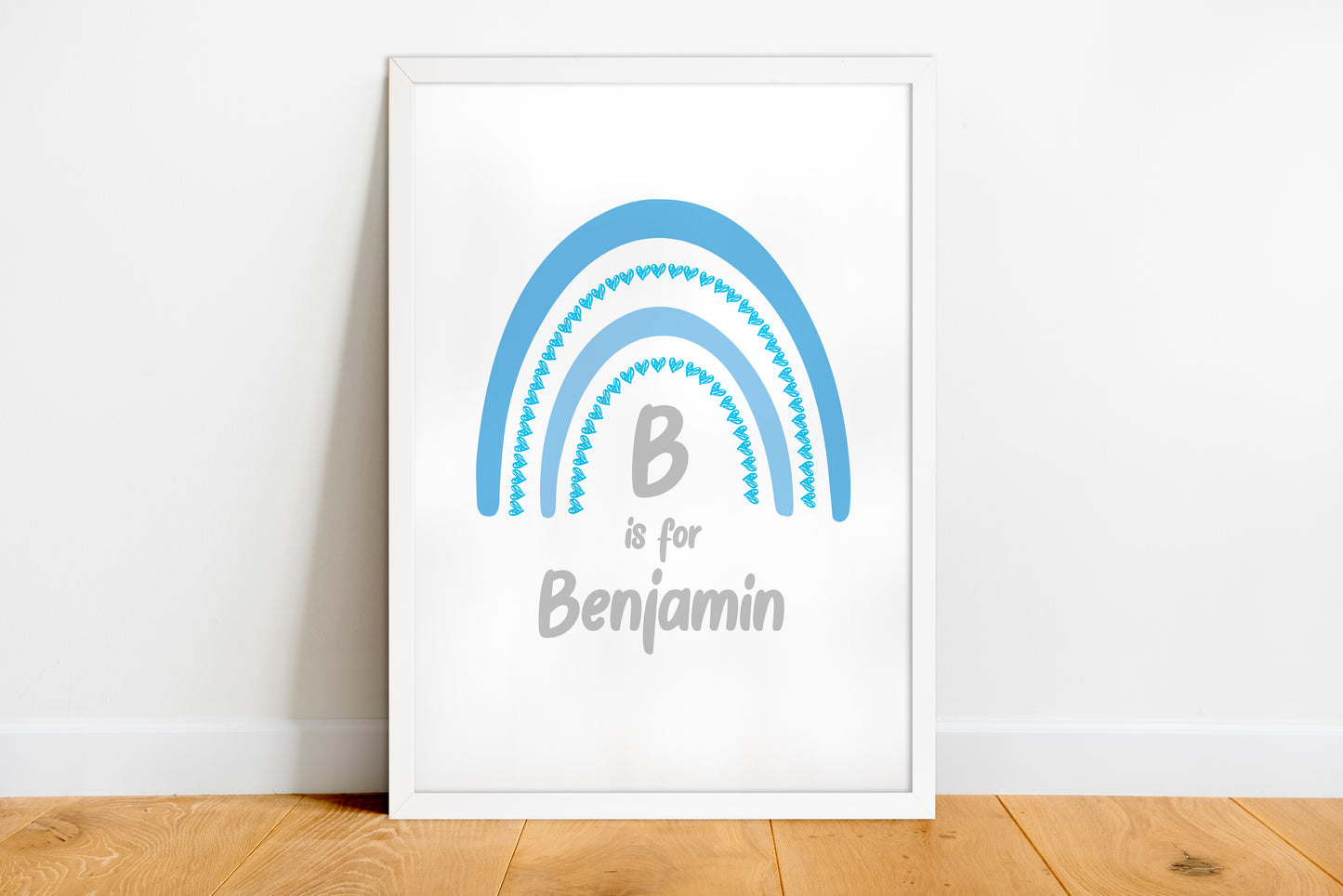 Framed artwork with a blue rainbow and 'B is for Benjamin' text on a white wall.